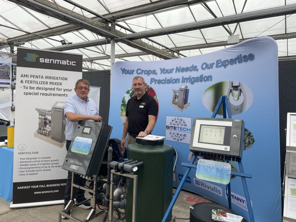 Sitetech | We're Exhibiting at Four Oaks Trade Show 2026: Meet Us on Stand D98 Simon from Sitetech with Kristoffer from DGT by Senmatic beside the AMI Simplex fertiliser mixer and LCC2 Touch climate computer on stand D98 at Four Oaks 2026